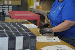 An eFulfillment Service employee is shown putting packages together. Only her hands are visible, woorking on the task.