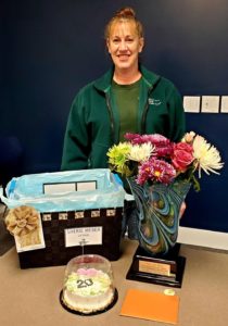 Photo of Sharie Weber smiling and standing behind her Ceremony-in-a-box.