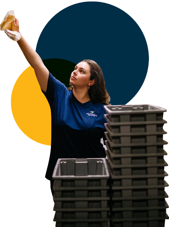 eFulfillment Service Employee With Stacked Bins Reaching Left