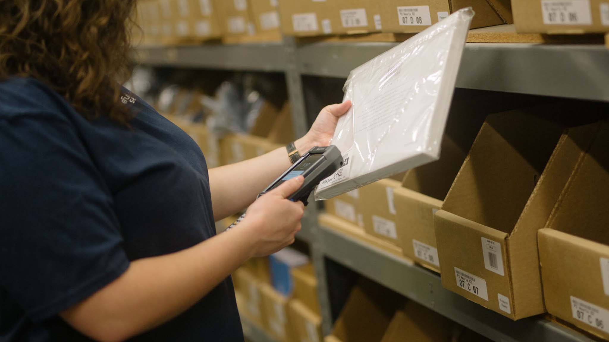 warehouse worker picking an order from a storage bin