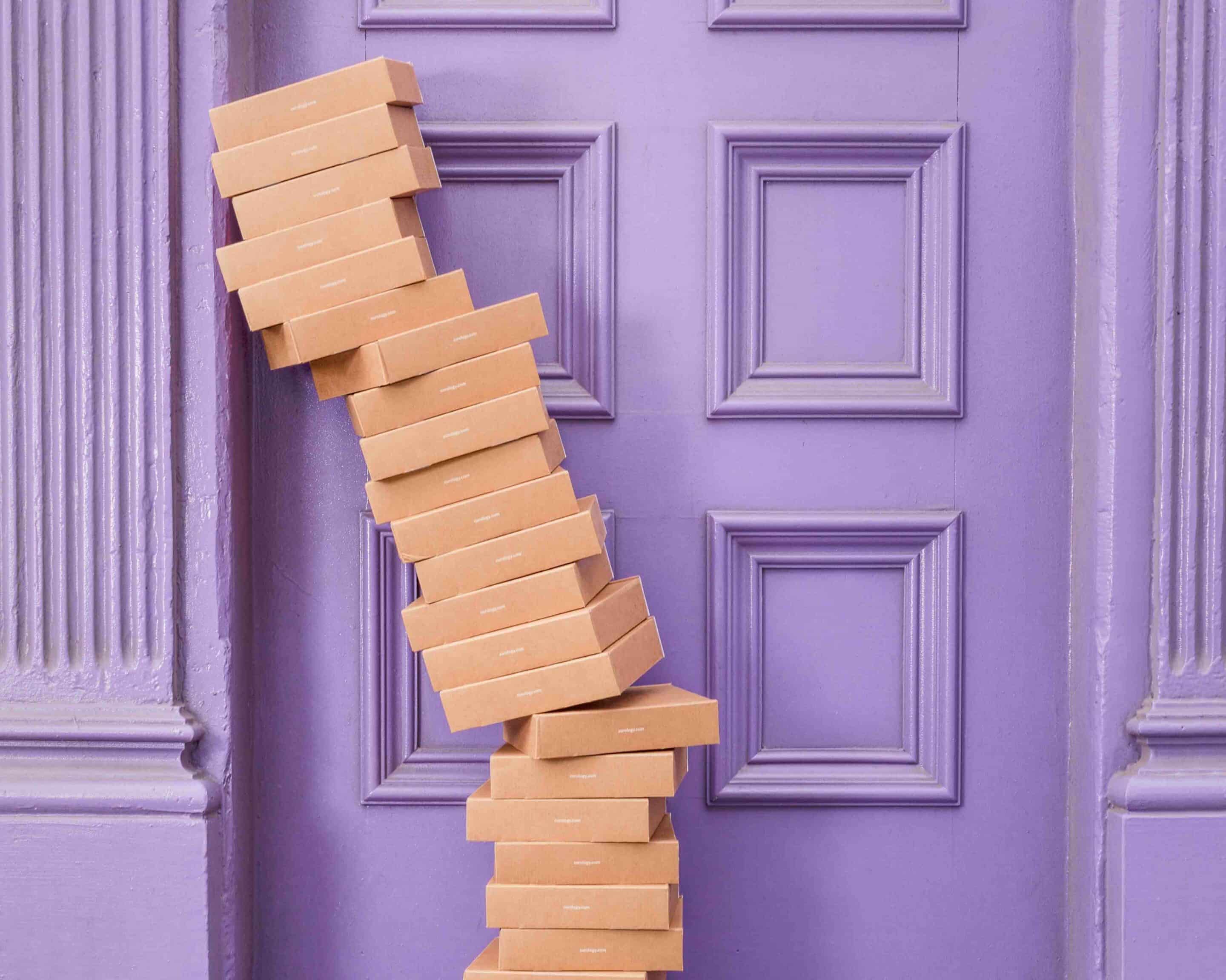 Photo of a stack of boxes in front of a purple door.