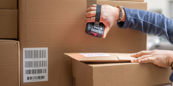 image of a person scanning the barcode of a box in a warehouse